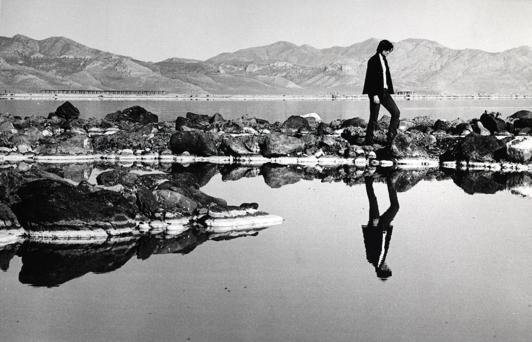 a man walking on rocks in water